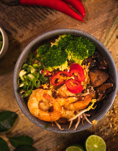 Laksa topped with prawns, spring onion, chilli, broccoli and mushrooms